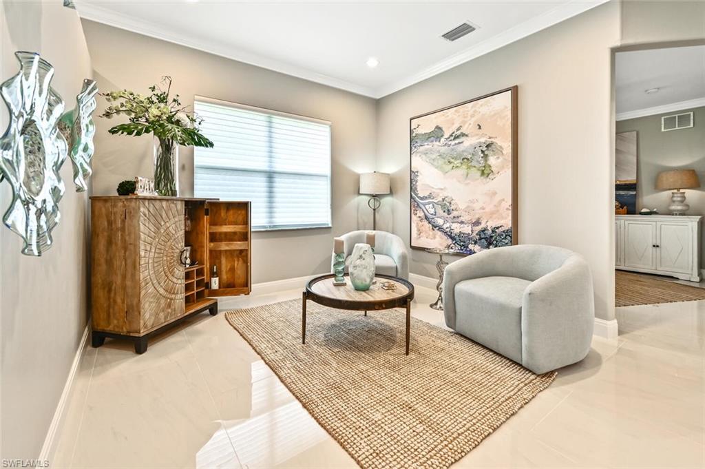 5616 Lago Villaggio Way Naples, FL 34104 - Photo 16 of 43 a living room with furniture and a flat screen tv