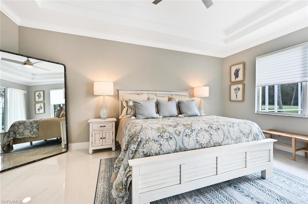 5616 Lago Villaggio Way Naples, FL 34104 - Photo 18 of 43 a bedroom with a bed and a walk in closet