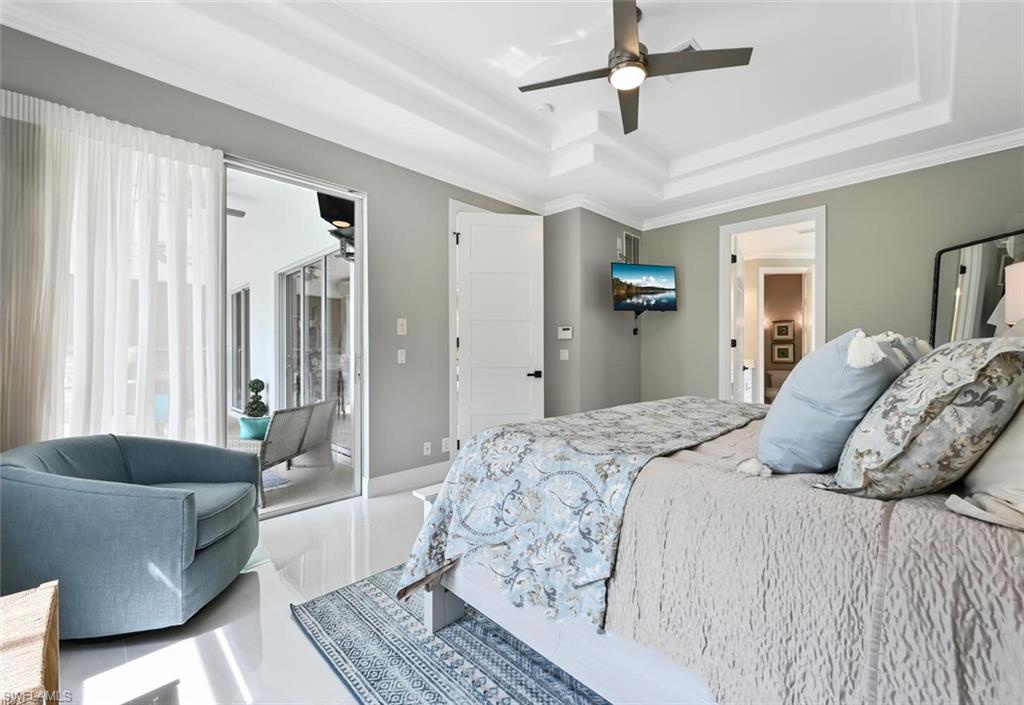 5616 Lago Villaggio Way Naples, FL 34104 - Photo 19 of 43 a bedroom with a bed ceiling fan and a window