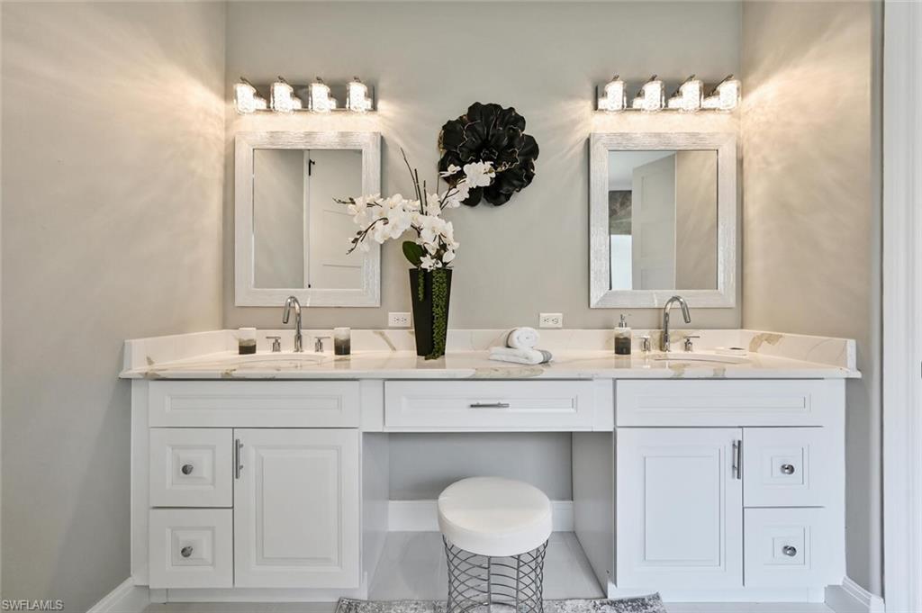 5616 Lago Villaggio Way Naples, FL 34104 - Photo 20 of 43 a bathroom with a double vanity sink and a mirror