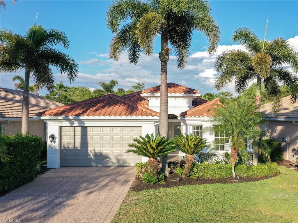 5616 Lago Villaggio Way Naples, FL 34104 - Photo 2 of 43 a front view of a house with a garden and swimming pool