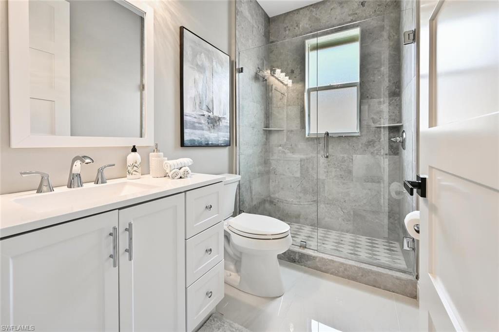 5616 Lago Villaggio Way Naples, FL 34104 - Photo 23 of 43 a bathroom with a sink toilet and shower