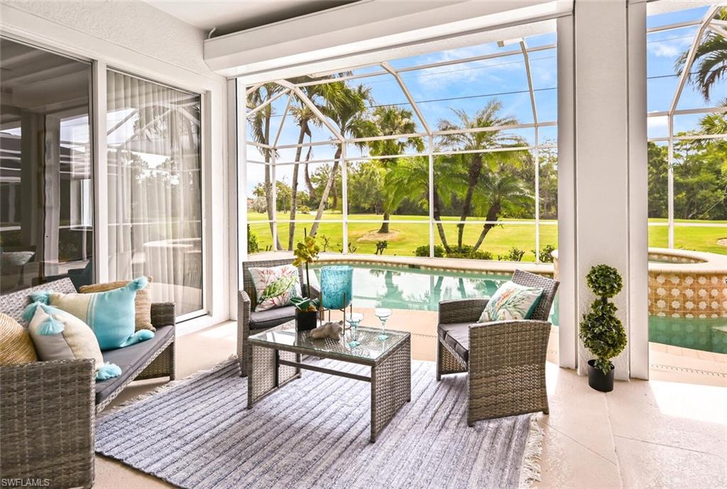 5616 Lago Villaggio Way Naples, FL 34104 - Photo 24 of 43 a living room with furniture and floor to ceiling windows