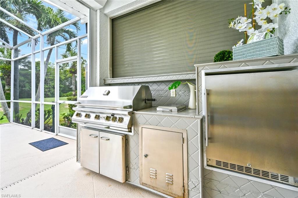5616 Lago Villaggio Way Naples, FL 34104 - Photo 27 of 43 a kitchen with a stove and a white wooden cabinets