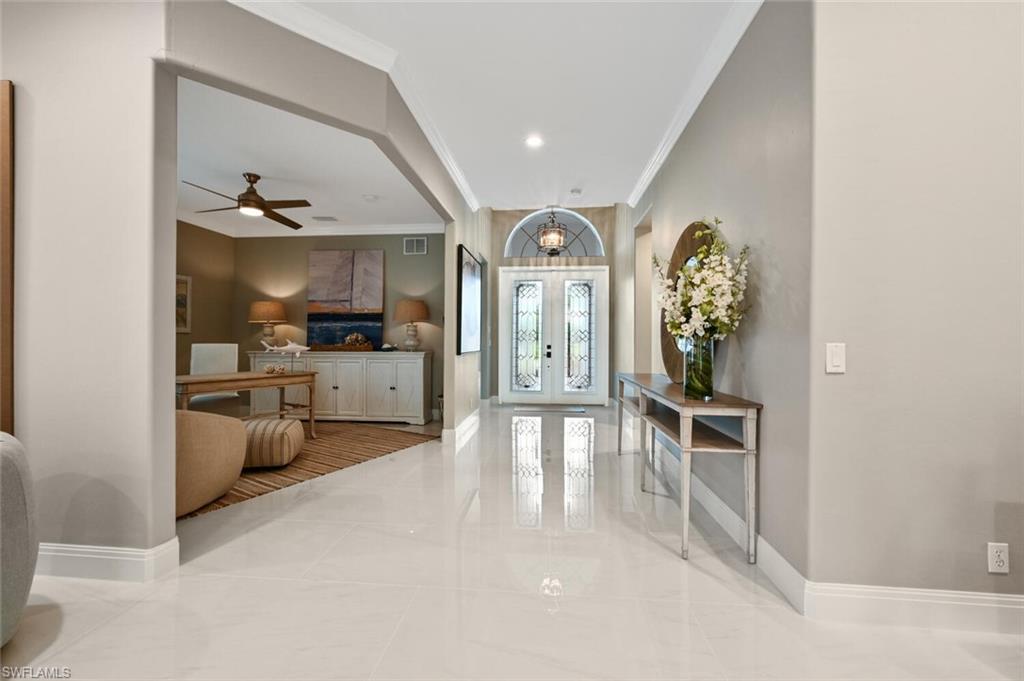5616 Lago Villaggio Way Naples, FL 34104 - Photo 3 of 43 a view of a hallway with living room and furniture