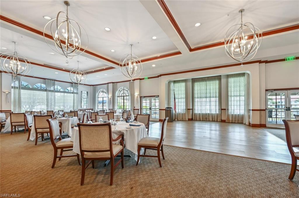 5616 Lago Villaggio Way Naples, FL 34104 - Photo 34 of 43 a view of a dining room with furniture wooden floor and chandelier