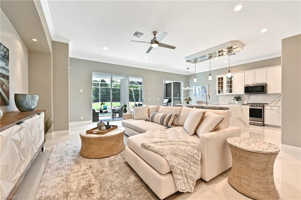 5616 Lago Villaggio Way Naples, FL 34104 - Photo 4 of 43 a living room with furniture fireplace and a flat screen tv