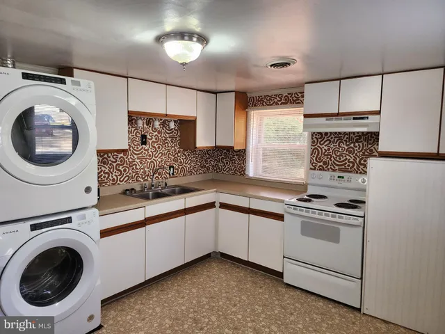 a kitchen with a sink a stove and cabinets