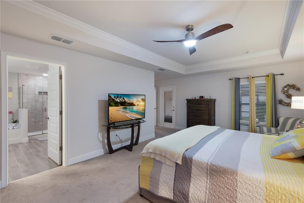 9318 46th Court East Parrish, FL 34219 - Photo 14 of 35 a bedroom with a bed and a flat screen tv