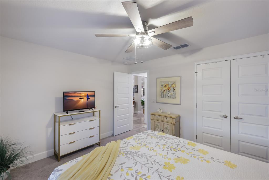 9318 46th Court East Parrish, FL 34219 - Photo 20 of 35 a bedroom with a bed and a flat tv screen on dresser