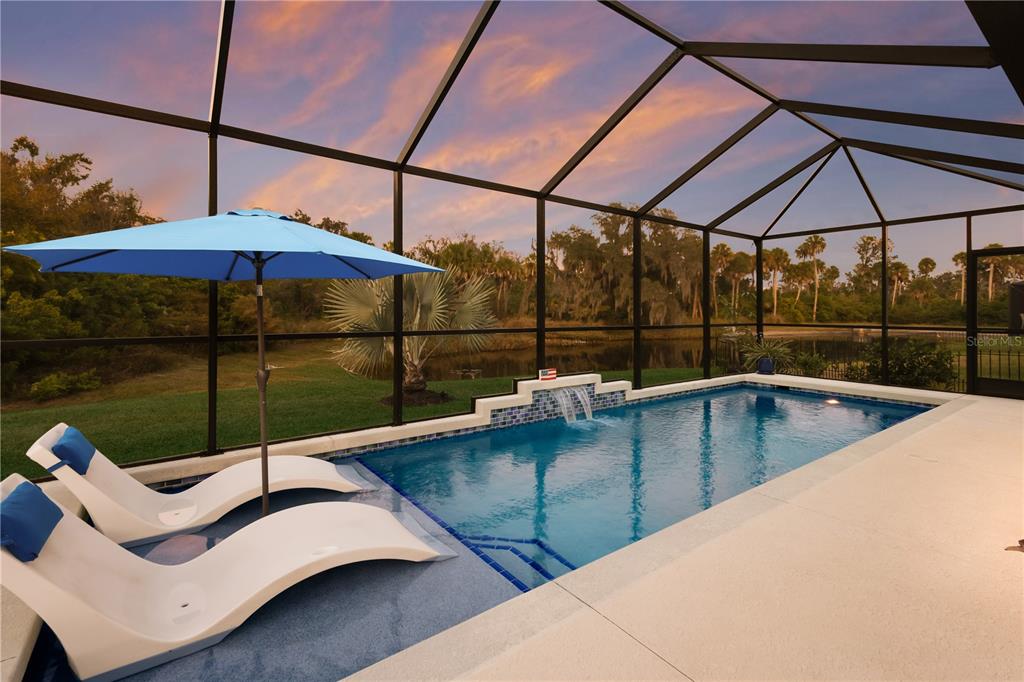 9318 46th Court East Parrish, FL 34219 - Photo 2 of 35 a view of a patio with a table and chairs under an umbrella