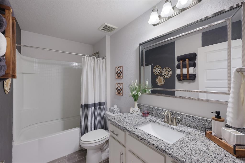 9318 46th Court East Parrish, FL 34219 - Photo 21 of 35 a bathroom with a granite countertop sink toilet and shower