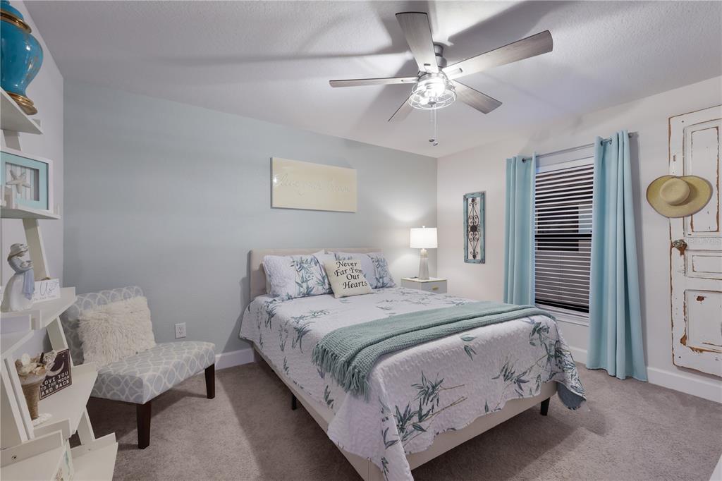 9318 46th Court East Parrish, FL 34219 - Photo 22 of 35 a bedroom with a bed and a chandelier