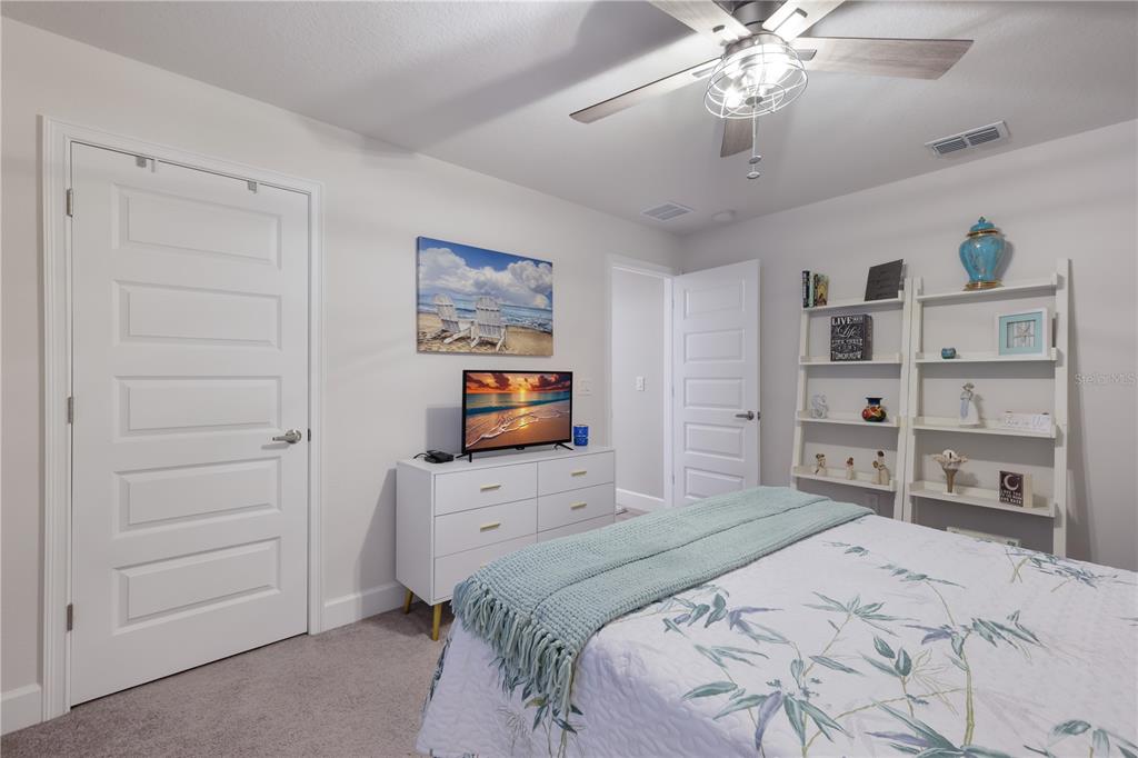 9318 46th Court East Parrish, FL 34219 - Photo 23 of 35 a bedroom with a bed and a flat screen tv