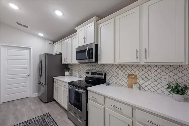 a kitchen with stainless steel appliances white cabinets and a sink