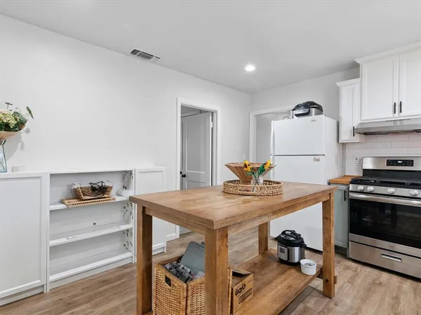 a kitchen with a table chairs stove and cabinets