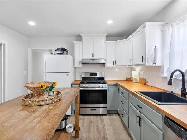a kitchen with stainless steel appliances granite countertop a stove a sink and a refrigerator