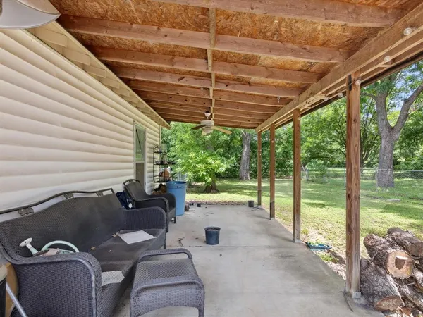 a roof deck with table and chairs and couches with wooden floor and fence