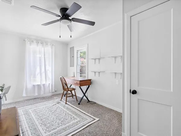 a view of a livingroom with wooden floor and a ceiling fan
