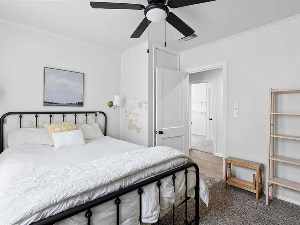 a bedroom with a large bed and a chandelier