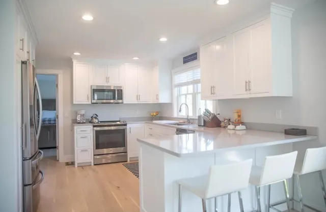 a kitchen with kitchen island granite countertop a sink stove and refrigerator