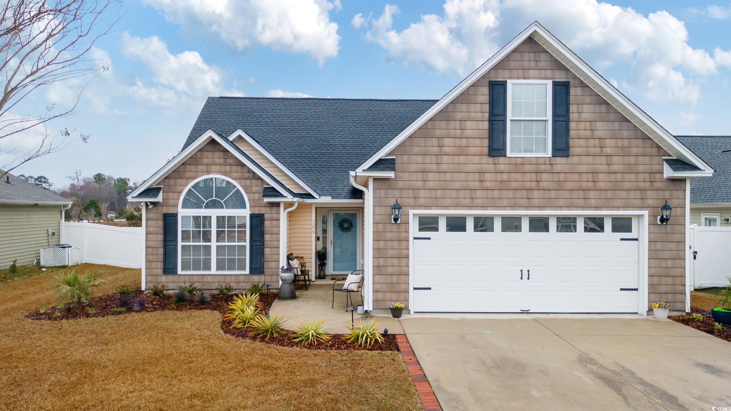 View of front of home with a garage and a front la