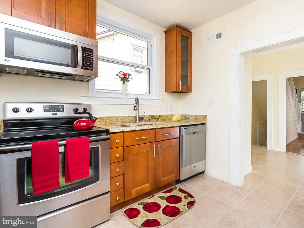 5006 Levindale Road Baltimore, MD 21215 - Photo 8 of 23 a kitchen with stainless steel appliances granite countertop a stove a sink and a microwave
