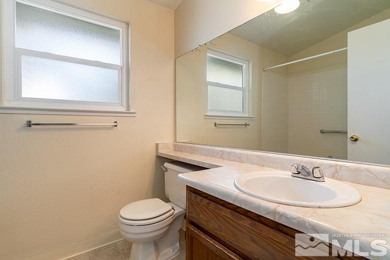 6082 Bankside Way Reno, NV 89523 - Photo 14 of 17 a bathroom with a granite countertop toilet sink and mirror