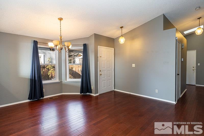 6082 Bankside Way Reno, NV 89523 - Photo 3 of 17 a view of a hallway with wooden floor and a chandelier