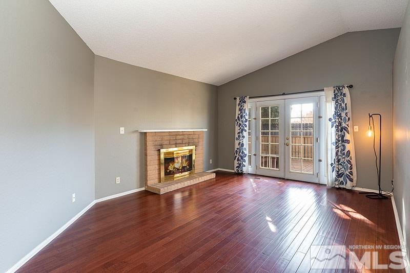 6082 Bankside Way Reno, NV 89523 - Photo 5 of 17 an empty room with wooden floor fireplace and windows