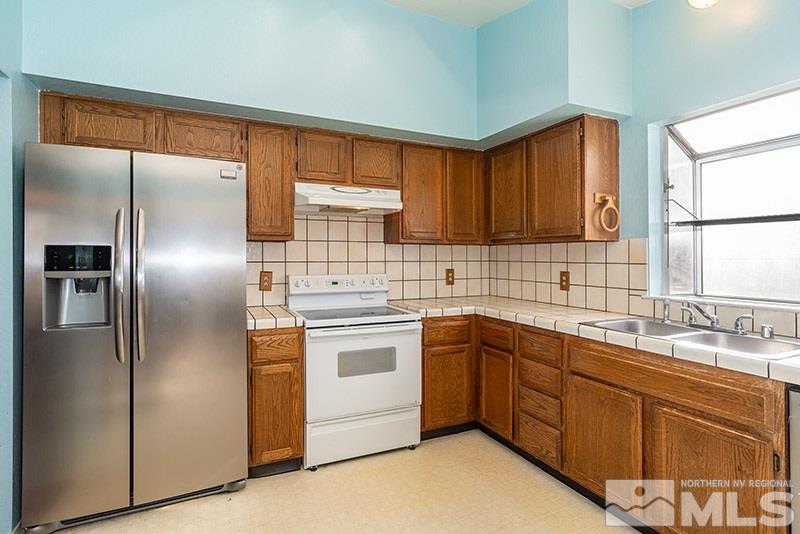 6082 Bankside Way Reno, NV 89523 - Photo 6 of 17 a kitchen with stainless steel appliances granite countertop a sink stove and refrigerator