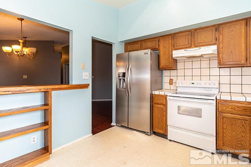 6082 Bankside Way Reno, NV 89523 - Photo 8 of 17 a kitchen with stainless steel appliances a refrigerator and a stove