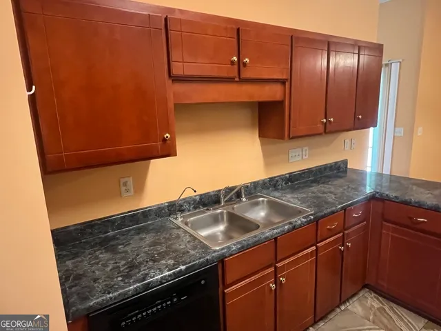 a kitchen with granite countertop a sink and cabinets