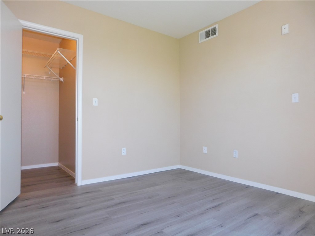 7255 West Sunset Road, Unit 2029 Las Vegas, NV 89113 - Photo 17 of 21 This spacious bedroom offers ample storage with its large closet, featuring durable wood flooring.