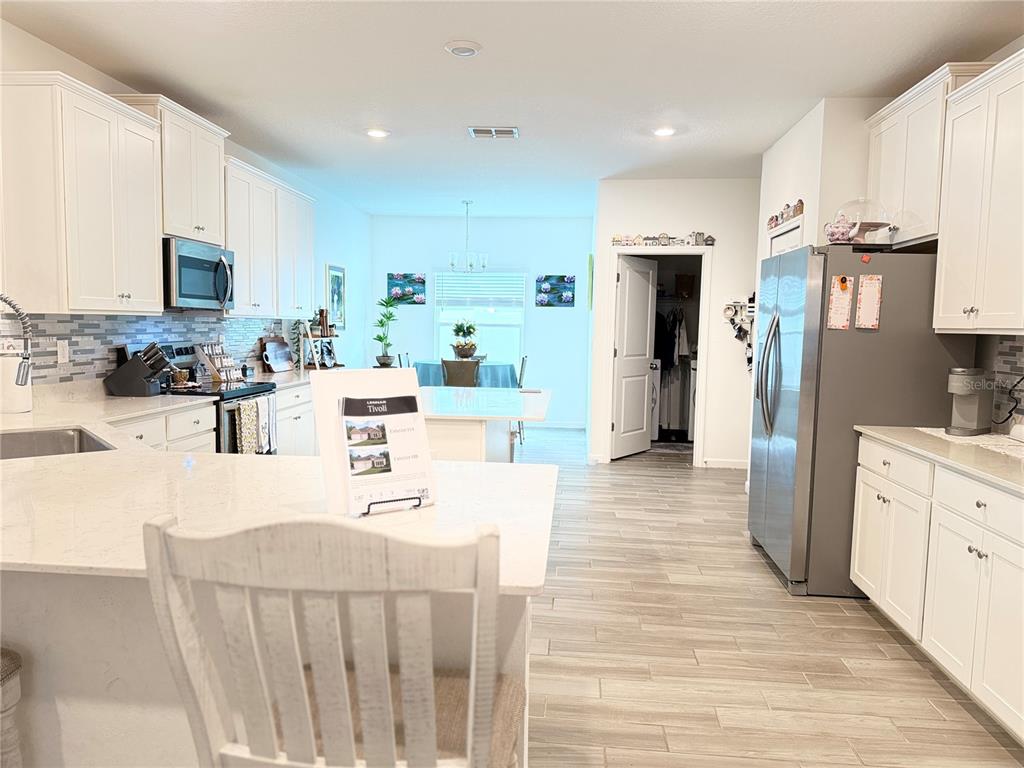 7656 Southwest 74th Loop Ocala, FL 34474 - Photo 24 of 95 a kitchen with stainless steel appliances kitchen island granite countertop a refrigerator and microwave