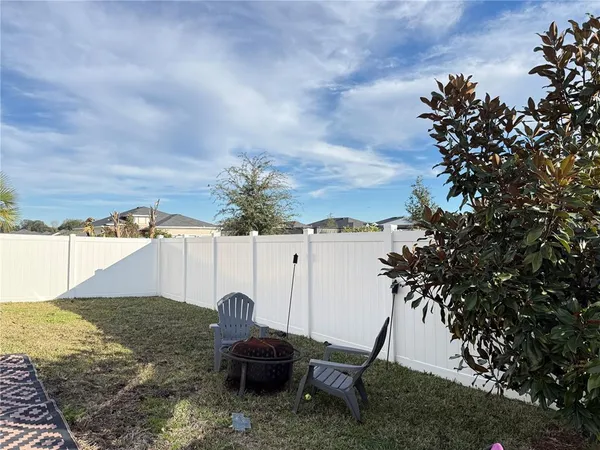 a backyard of a house with table and chairs