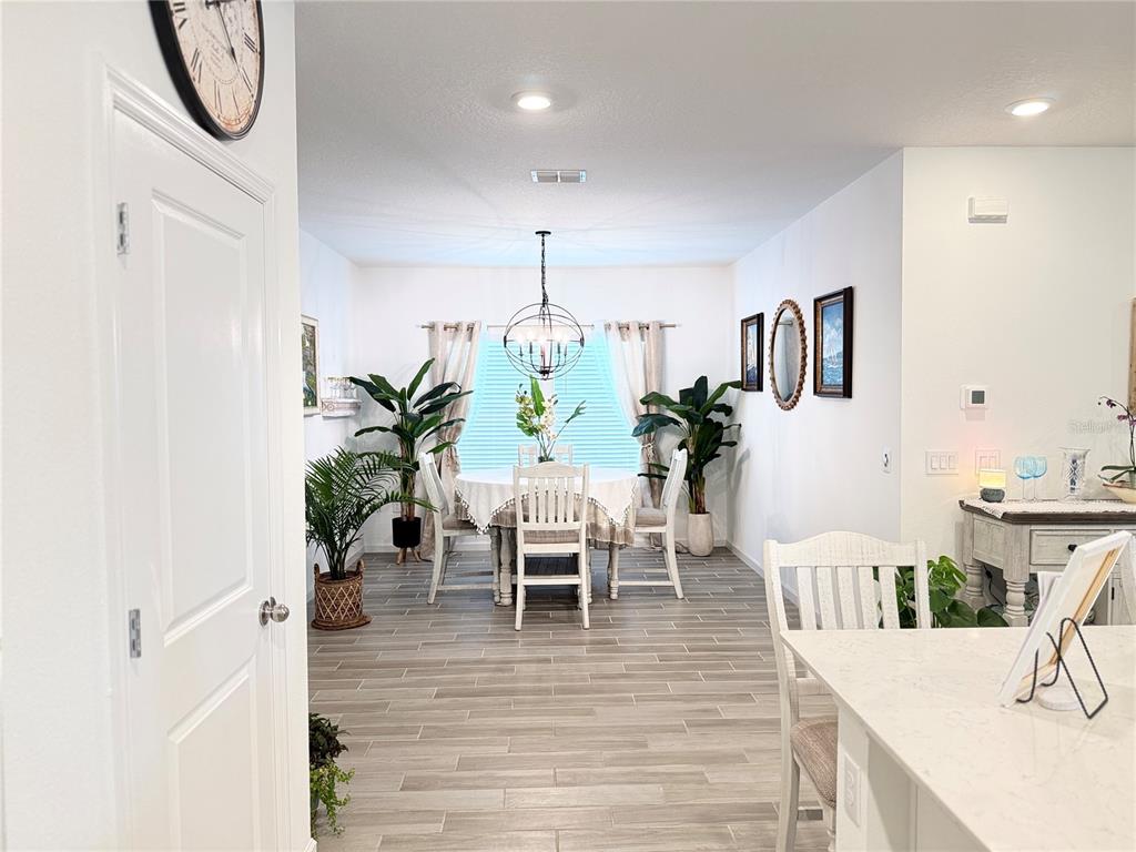 7656 Southwest 74th Loop Ocala, FL 34474 - Photo 36 of 95 a view of a dining room and livingroom with furniture wooden floor a chandelier