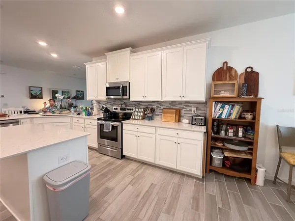 a kitchen with white cabinets and appliances
