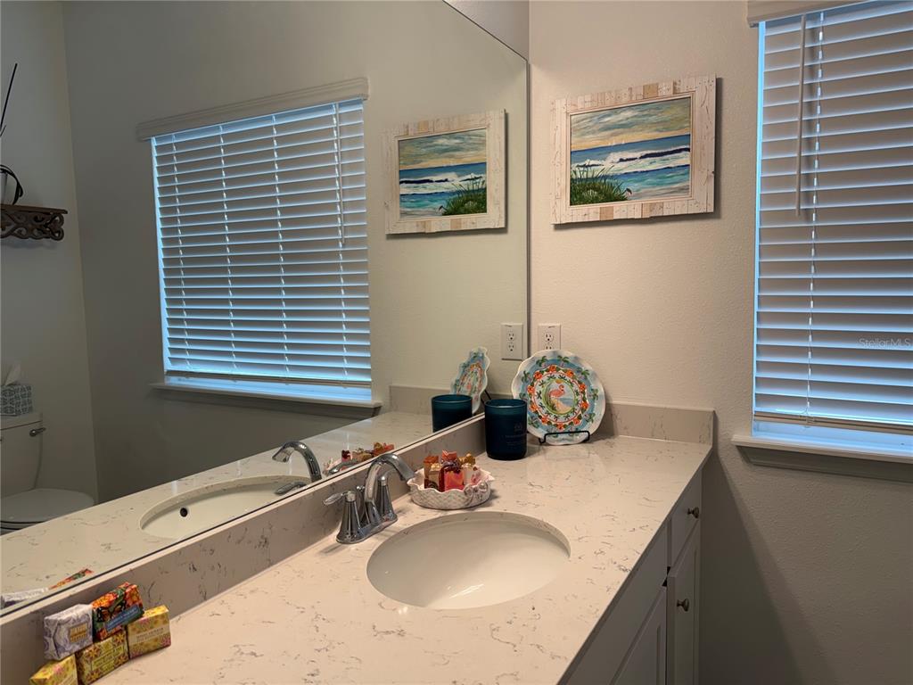 7656 Southwest 74th Loop Ocala, FL 34474 - Photo 51 of 95 a bathroom with a granite countertop sink and a mirror
