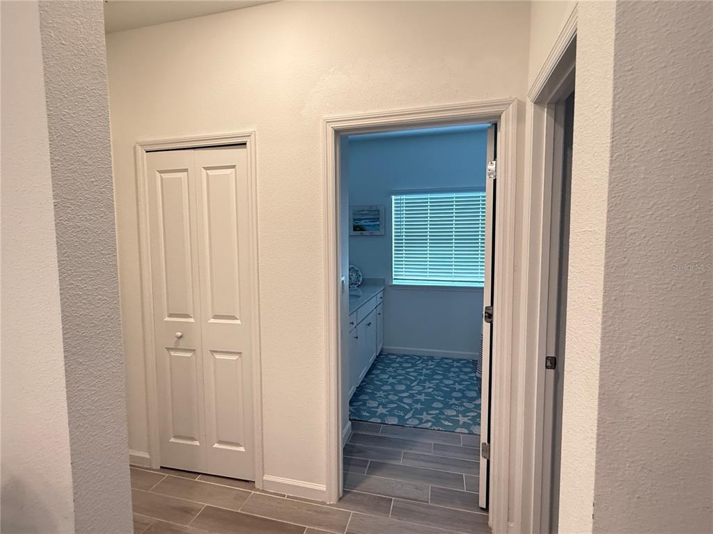 7656 Southwest 74th Loop Ocala, FL 34474 - Photo 59 of 95 a view of a hallway with wooden floor and a bathroom