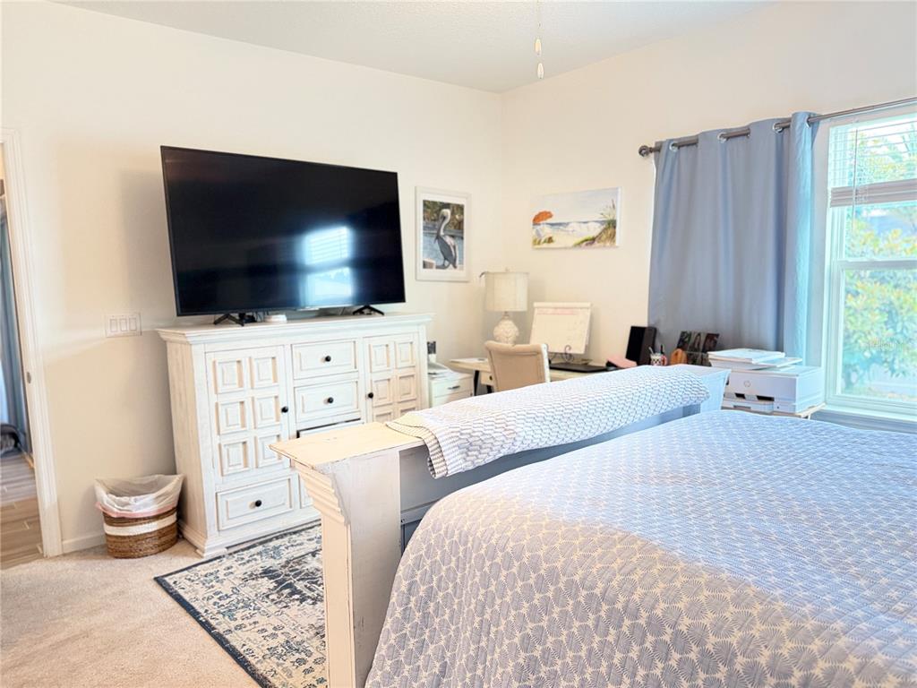 7656 Southwest 74th Loop Ocala, FL 34474 - Photo 65 of 95 a bedroom with a bed and a flat screen tv