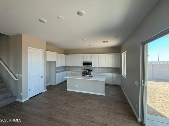 a view of kitchen with sink microwave and refrigerator