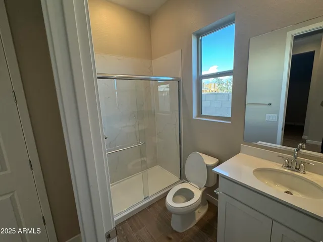 a bathroom with a granite countertop sink toilet a mirror and shower