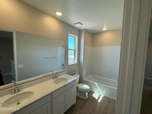 a bathroom with a granite countertop sink a toilet and shower