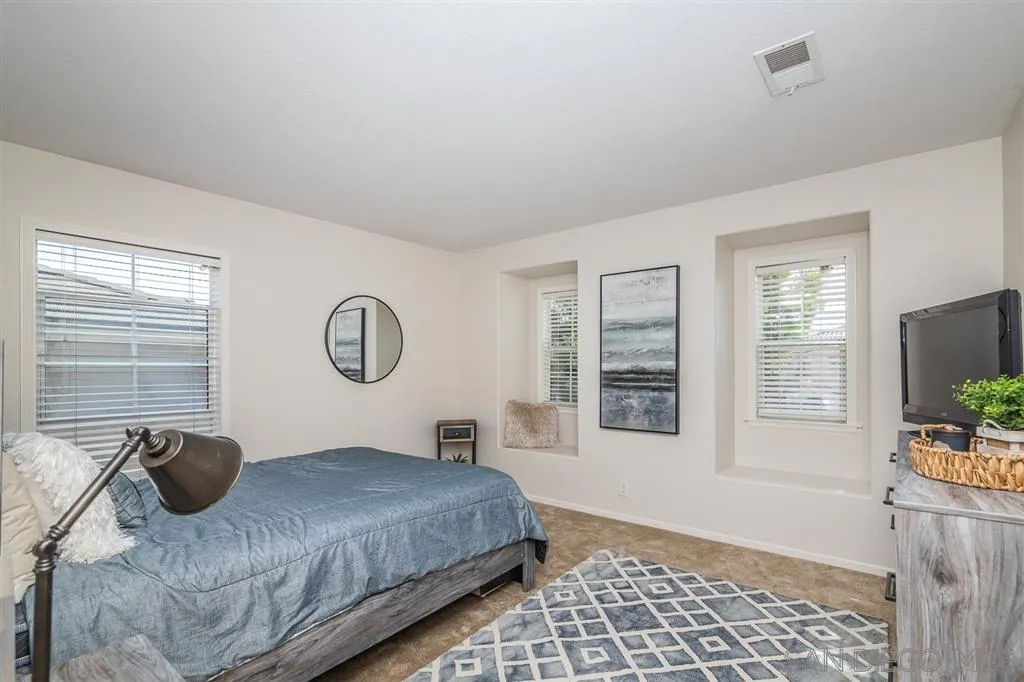 1088 Greenway Road Oceanside, CA 92057 - Photo 15 of 25 a bedroom with a bed and a flat tv screen on dresser