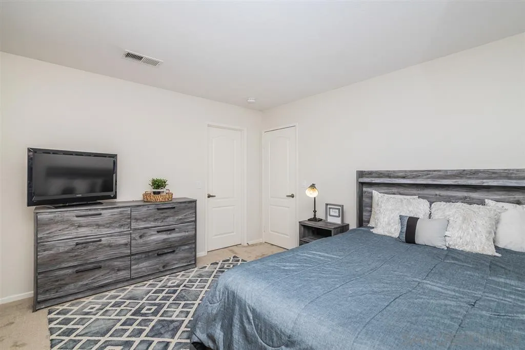 1088 Greenway Road Oceanside, CA 92057 - Photo 16 of 25 a bedroom with a bed and flat screen tv