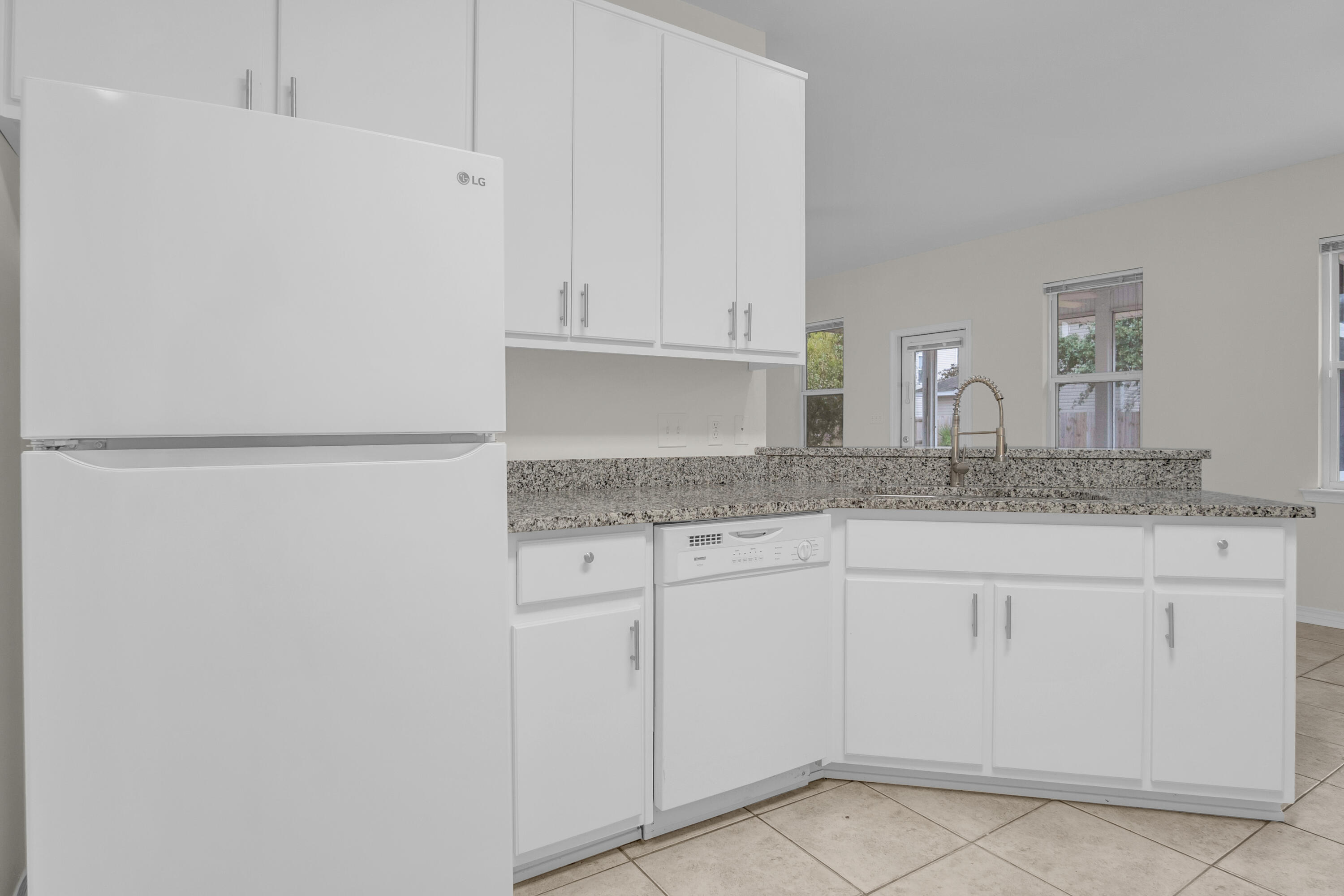 63 Las Roblas Grande Drive Santa Rosa Beach, FL 32459 - Photo 20 of 28 a kitchen with granite countertop white cabinets and sink