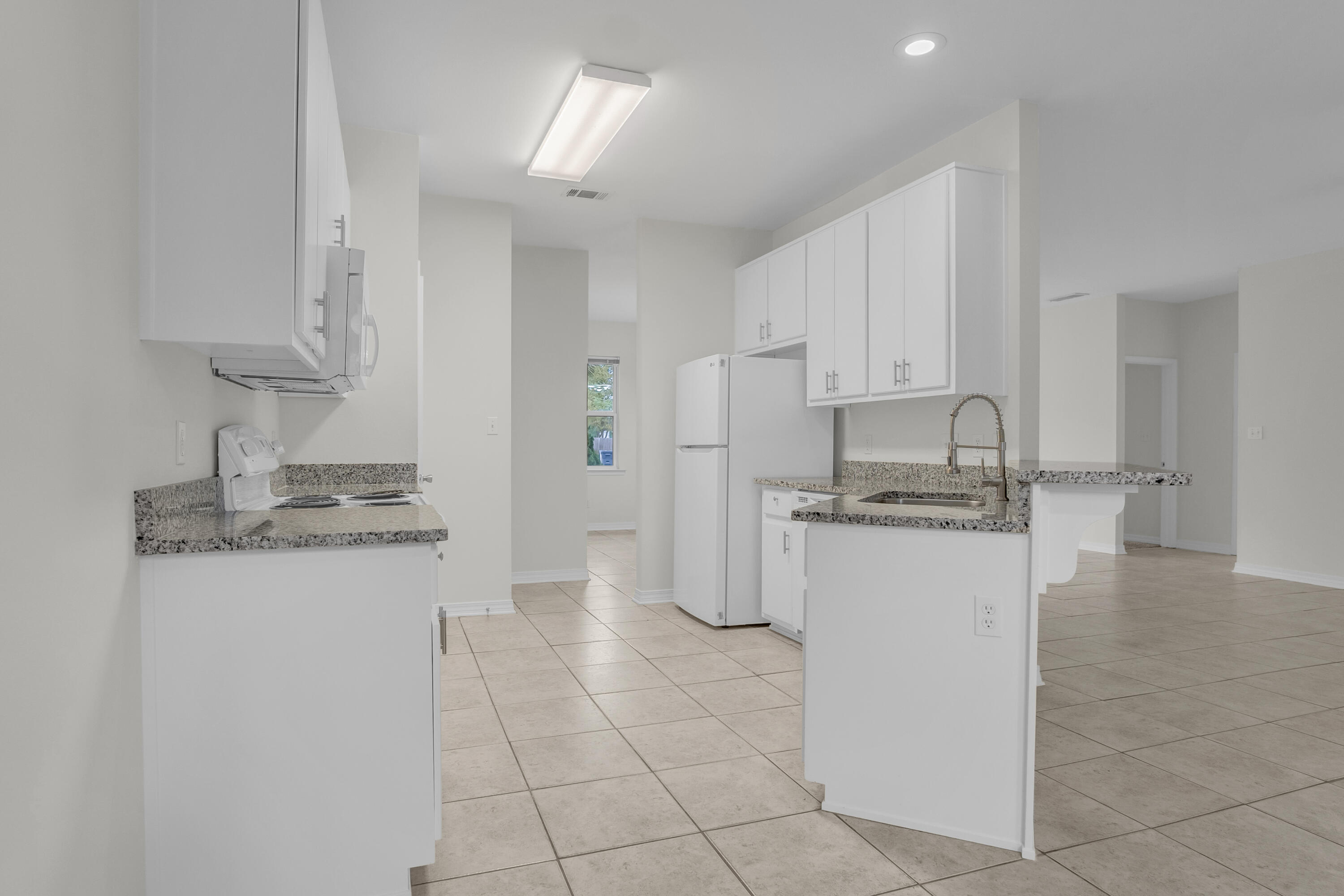 63 Las Roblas Grande Drive Santa Rosa Beach, FL 32459 - Photo 6 of 28 a kitchen with stainless steel appliances granite countertop a sink a stove a refrigerator and cabinets