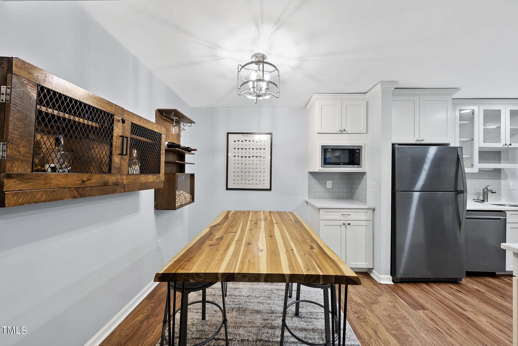1309 Hillbrow Lane, Unit 103 Raleigh, NC 27615 - Photo 13 of 25 a kitchen with stainless steel appliances granite countertop a refrigerator a stove top oven a sink dishwasher and white cabinets with wooden floor