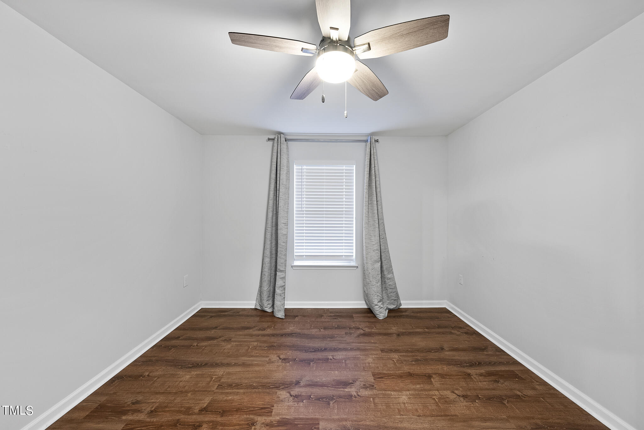 1309 Hillbrow Lane, Unit 103 Raleigh, NC 27615 - Photo 18 of 25 an empty room with wooden floor ceiling fan and carpet